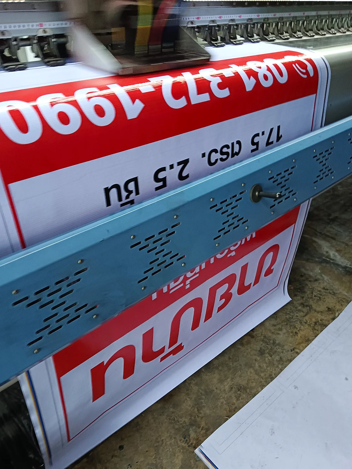 เครื่องพิมพ์ไวนิลกำลังพิมพ์ป้ายขายบ้าน สีแดง–ขาว แบบเต็มหน้ากว้าง