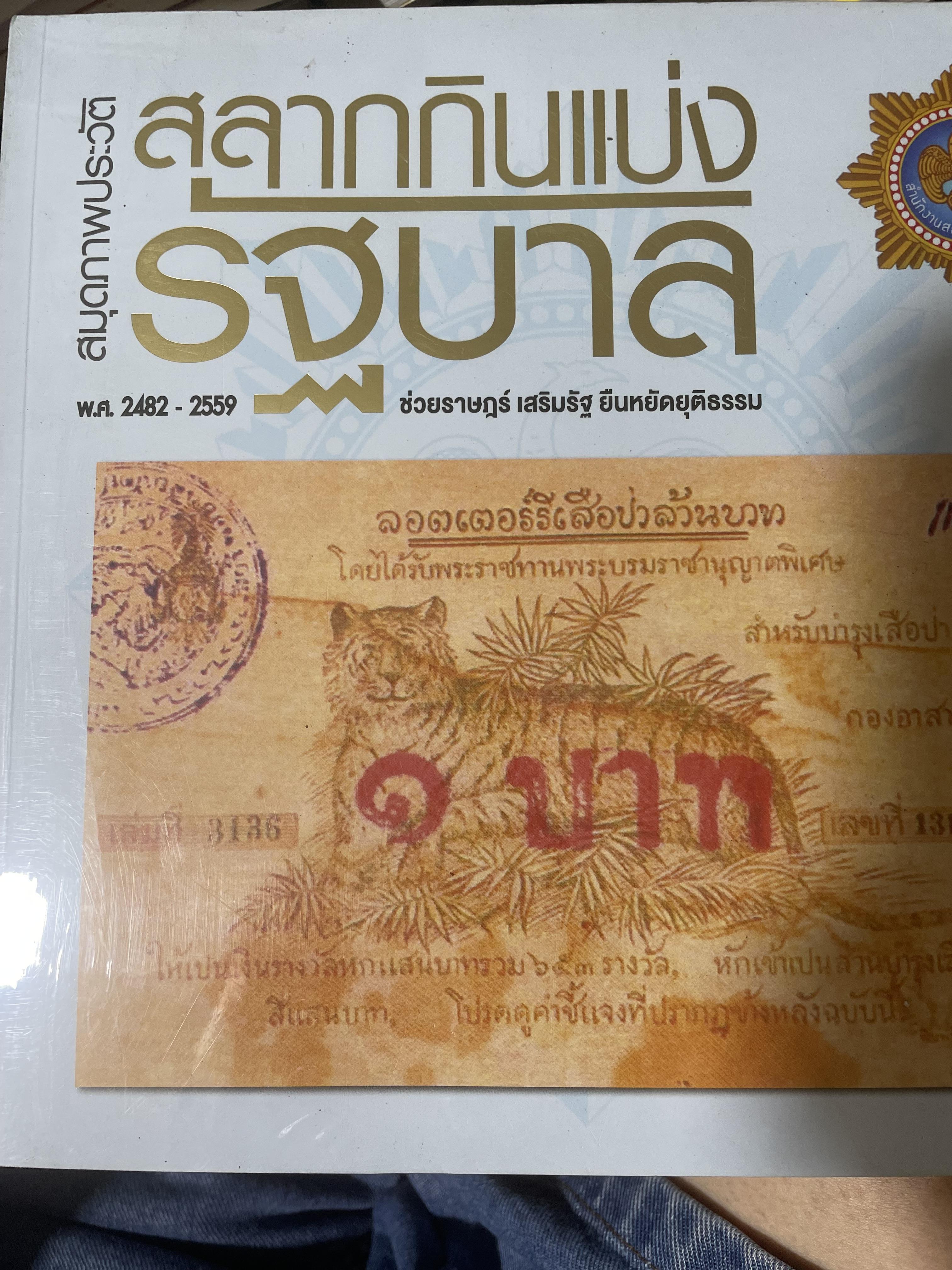 สมุดภาพประวัติ สลากกินแบ่งรัฐบาล พ.ศ.2482-2559 ช่วยราษฎร์ เสริมรัฐ ยืนหยัดยุติธรรม จัดทำโดย สำนักงานสลากกินแบ่งรัฐบาล 5 กก.